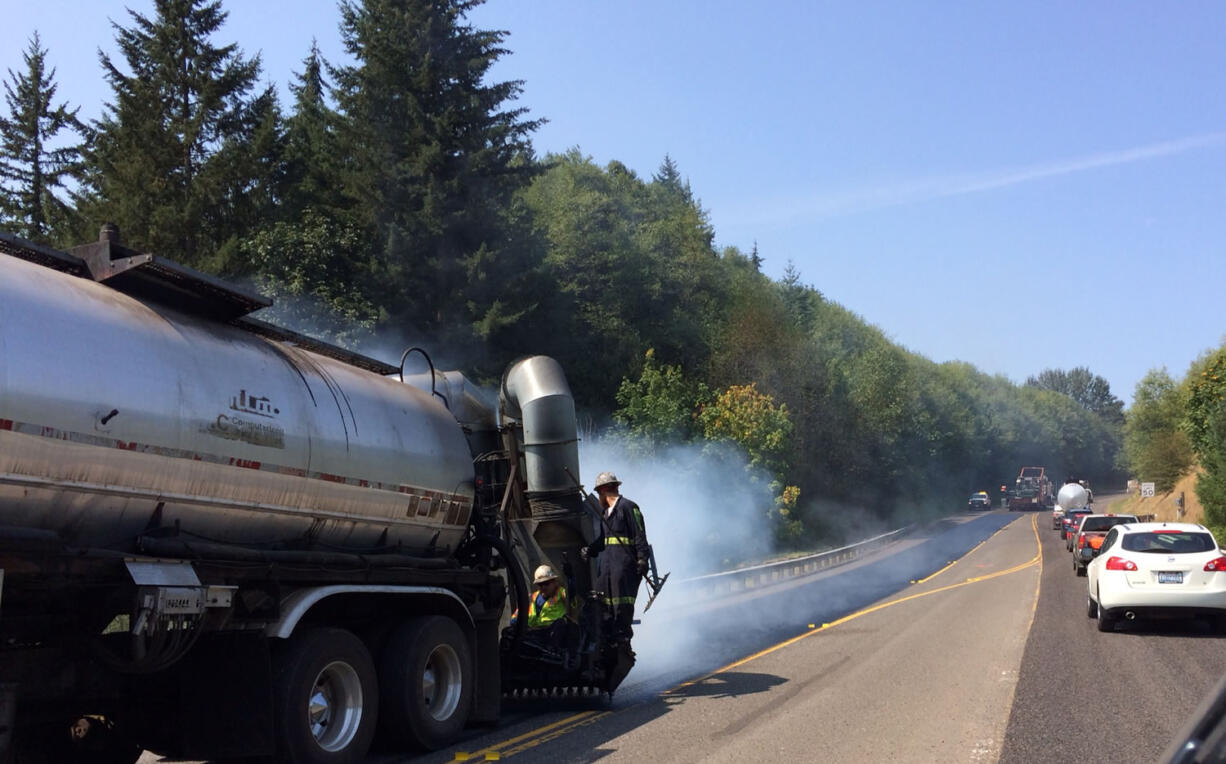 Asphalt workers resurface a section of La Center Road on Saturday.