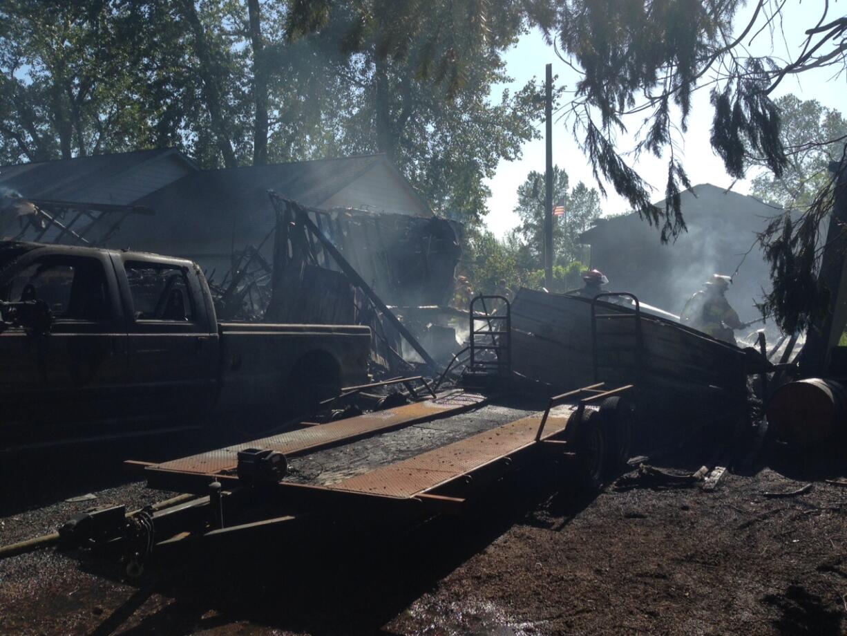 Firefighters work to mop up the scene of a two-alarm fire along Northeast 50th Avenue on Friday.