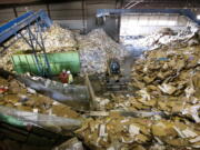 This November 2013 photo shows workers at West Vancouver Materials Recovery Center sorting through tons of cardboard, paper and other recycled materials.