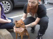 Neighbor Nate Young rescued Roski, a miniature pinscher, from a burning unit at The Avenues apartments in Vancouver on Wednesday.