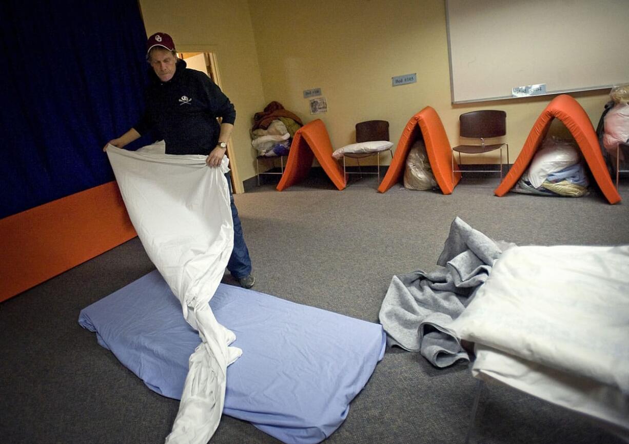 A man gets a bed ready for the night at the Winter Hospitality Overflow (WHO) men's shelter at St. Paul Lutheran Church in December 2011. The shelters expect to be full for the season once they open for 2015 on Nov. 2.