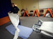 A man gets a bed ready for the night at the Winter Hospitality Overflow (WHO) men's shelter at St. Paul Lutheran Church in December 2011. The shelters expect to be full for the season once they open for 2015 on Nov. 2.