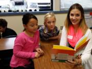 Gause Elementary School students Jayda Peterson and Avery Price read with Hana Nekvapil, a student in the WHS child development class.