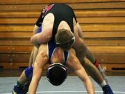 Bryant Elliott hangs on to Manny Mendez during the second round of the Pacific Coast Championships Friday, at Hudson's Bay High School. The Camas Papermaker beat his rival from Mountain View 5-4 and finished in fourth place. Talon Edmiston also took fourth place for Camas.