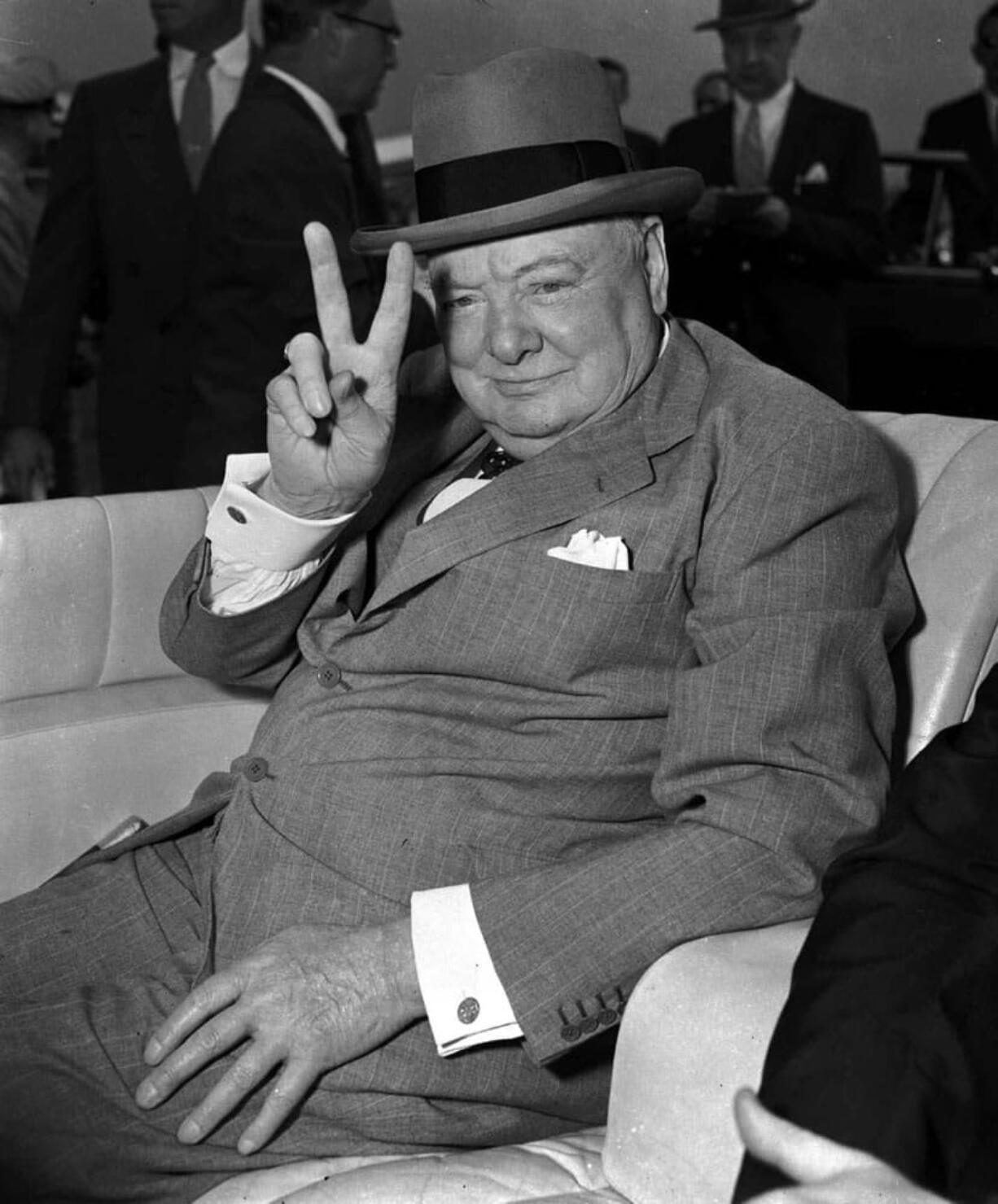 British Prime Minister Winston Churchill responds with the &quot;V&quot; for victory sign he made a trademark during World War II as spectators cheer his arrival at National Airport in Washington, D.C., June 25, 1954.