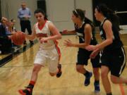 Alyssa Blankenship dribbles the basketball by two Hockinson Hawks Friday, at Washougal High School.