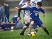 Mountain View's Isaac Strever (12), battling against Heritage High's Grant Thiriot in Friday's match, has six goals and two assists six games into the season.