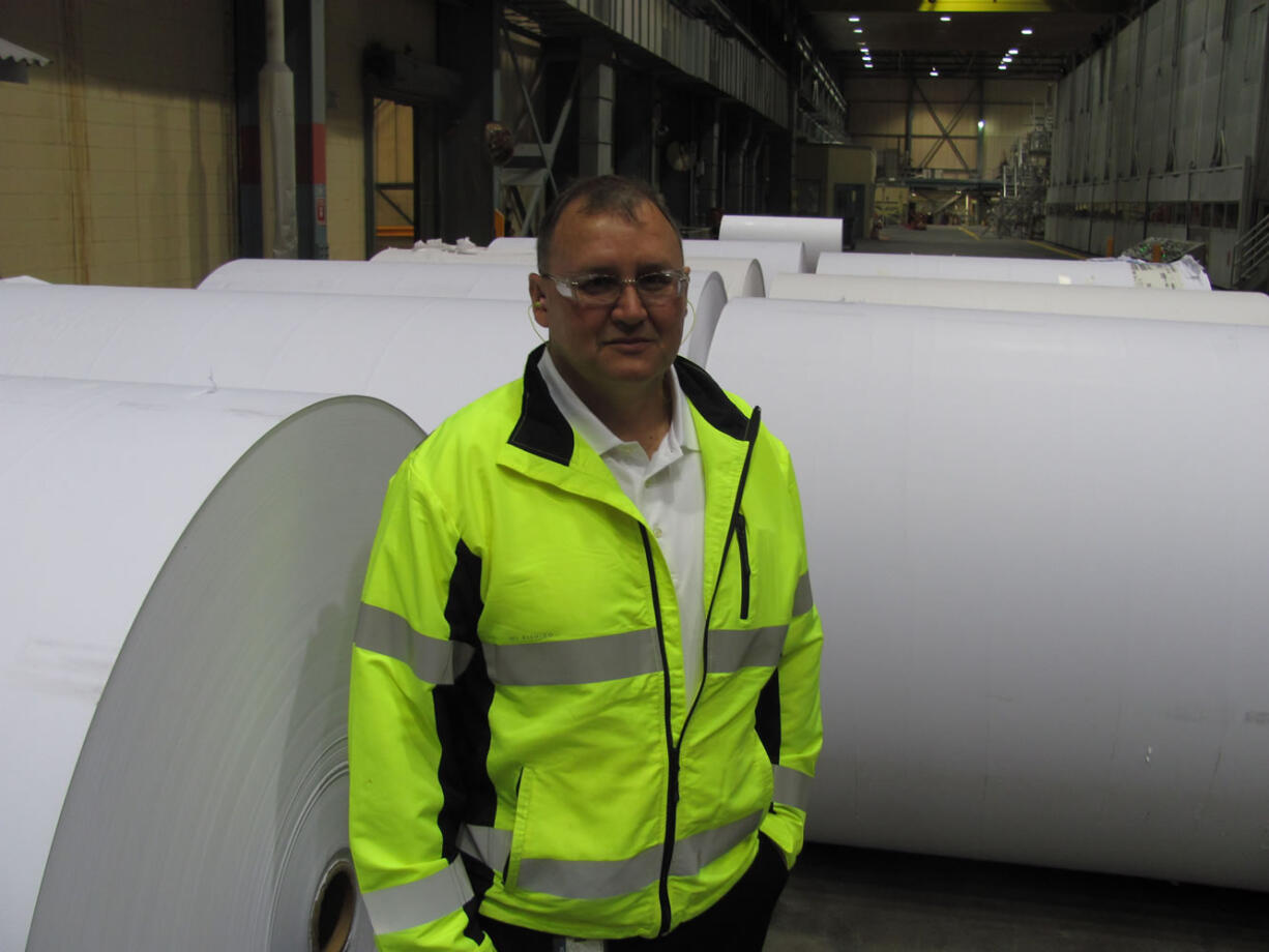 Joe Ertolacci, the new manager of the Georgia-Pacific mill, in Camas, stands next to communication paper rolls in the number 20 building.