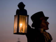 Dressed in period garb, Greg Shine, chief ranger and historian at Fort Vancouver, holds a lantern during a candlelight tour.