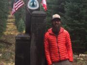 Anthony Mannello stops for a photo at the U.S.-Canadian border on the Pacific Crest National Scenic Trail.