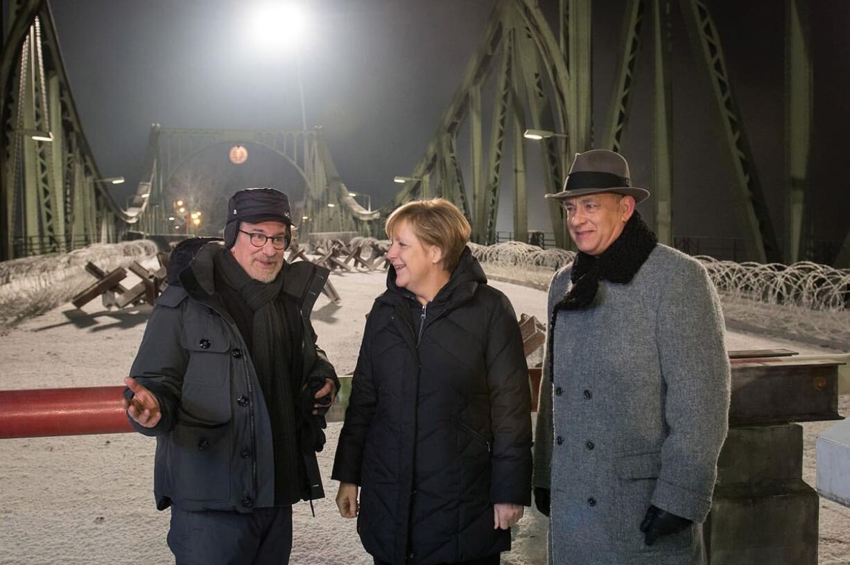 German Chancellor Angela Merkel, center, talks on the set of the movie &quot;Bridge of Spies&quot; with director Steven Spielberg, left, and actor Tom Hanks on Nov. 28 in Berlin.