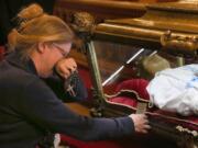 A parishoner becomes emotional as she kneels and prays beside the remains of St. Maria Goretti on Oct. 12 at St. John Cantius Church in Chicago.