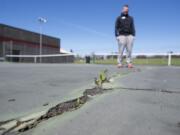 Vancouver Tennis Center manager Brent Waddle shows large cracks on the outdoor courts, Thursday, April 16, 2015.