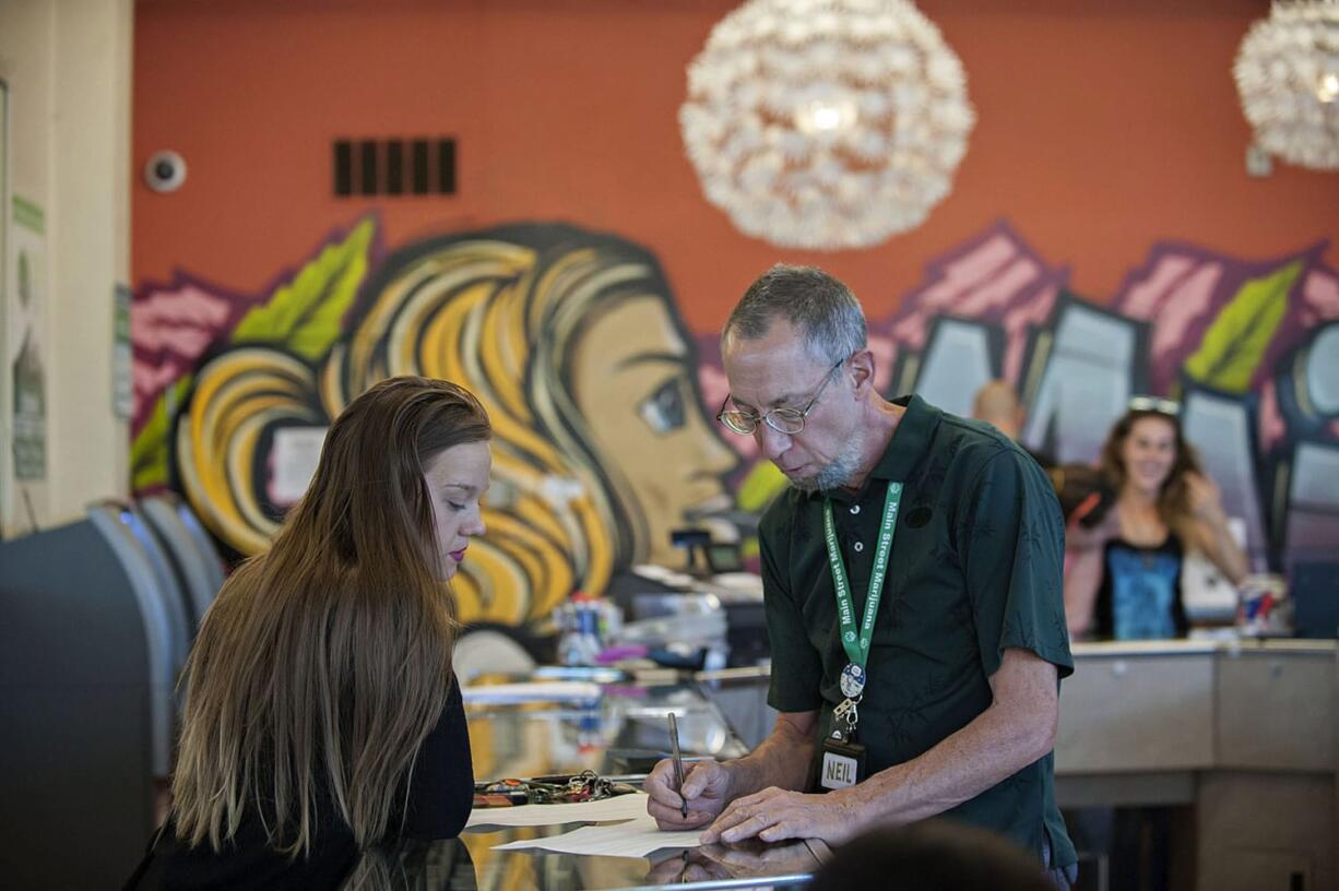 Jaci Cannon of Vancouver, left, shops at Main Street Marijuana with help from Neil McCauley on Monday afternoon. Cannon said she would consider shopping for marijuana in Oregon if it was convenient.