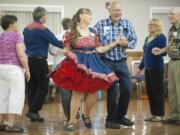 Carol Williamson, center, shows of her fancy Western outfit while dancing with the Happ Hoppers.