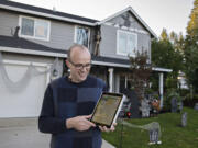 Jim Mains of Vancouver looks over the Nextdoor Treat Map on his iPad outside his home in Northwest neighborhood. People across the county are using the map to mark their homes as trick-or-treat friendly.