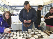 Bill Cole, owner of Nature's Wild Harvest, helps Melanie Kelly of Vancouver choose from a variety of wildflower honey Sunday at the Vancouver Farmers Market.