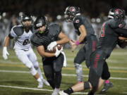 Camas' Jordan Del Moral, center, scrambles past Union defenders to score in the second quarter Friday night, Oct. 16, 2015 at Doc Harris Stadium in Camas.