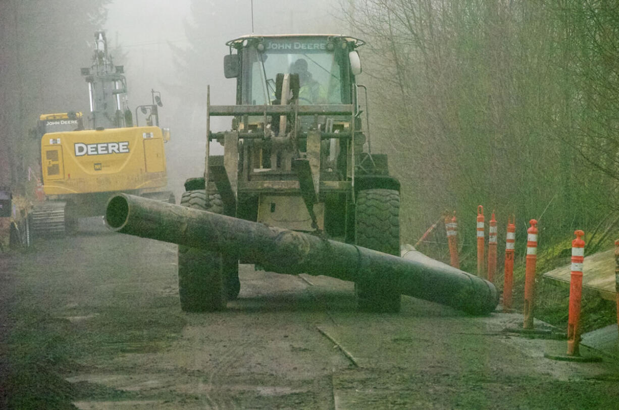 Crews install 16-inch wastewater pipe Tuesday along Northeast 10th Avenue.