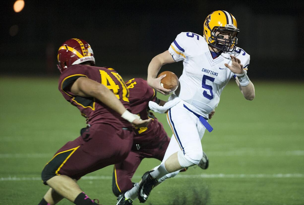 Columbia River&#039;s Garrett McKee (5) tries to get past Prairie&#039;s Lukas Daniel (40) and Abraham Ayala (44) in the second quarter Thursday night, Oct. 22, 2015 at Battle Ground High School.