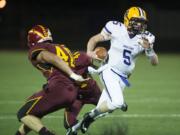 Columbia River&#039;s Garrett McKee (5) tries to get past Prairie&#039;s Lukas Daniel (40) and Abraham Ayala (44) in the second quarter Thursday night, Oct. 22, 2015 at Battle Ground High School.