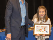 Ridgefield: Ridgefield School District Superintendent Nathan McCann congratulates Union Ridge Elementary School student Olivia Fenton on winning the Holiday Greeting Card Design Competition at a district board meeting on Dec.