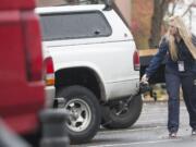 Parking enforcement officer Holly Naramore marks vehicle tires with chalk during her rounds Wednesday in downtown Vancouver. The city is conducting a survey about parking enforcement to see how residents feel about a boot-and-tow program.