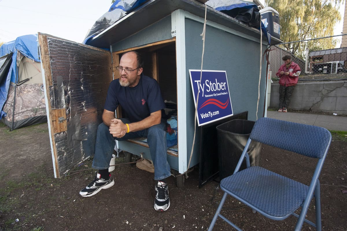 Lloyd Dodge sits in his hut Tuesday at a homeless camp near Share House in downtown Vancouver.