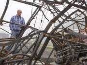 Jeramy Wilcox, project manager with the port of Camas-Washougal, looks at the small pile of refuse that survived the fire that destroyed 10 hangar bays Oct.