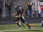 Camas' Jared Bentley scrambles past the defense to score a touchdown in the second quarter Friday night, Oct. 9, 2015 at Doc Harris Stadium.