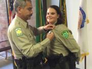 Veteran Clark County Sheriff&#039;s Deputy Greg Chaney pins a deputy&#039;s badge on his niece, Tina Wiggs, at her swearing-in ceremony Thursday. Wiggs was a police officer in the Metropolitan Nashville Police Department for 7 1/2  years before joining the Clark County Sheriff&#039;s Office.