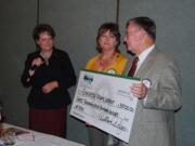 Ogden: Rotary of Greater Clark County President-Elect Robin Anderson, from left, and Dellan Redjou, past president of the Greater Clark County Rotary Foundation, presenting Evergreen School District Superintendent John Deeder with a check to thank the district for its help with the Rotary&#039;s rummage sale in June.