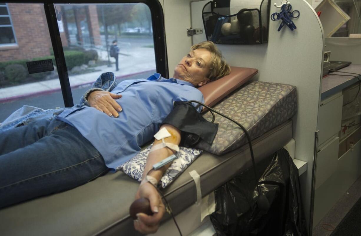 Kay Hust donates blood at the Clark County Emergency Services building in Vancouver. The event, held every two months at the county building, is known for the high number of regular donors.