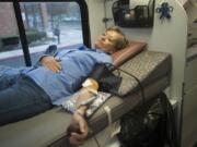 Kay Hust donates blood at the Clark County Emergency Services building in Vancouver. The event, held every two months at the county building, is known for the high number of regular donors.