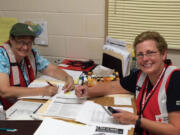 Tammy Sullivan of Camas, right, and fellow Red Cross volunteer Laurie Gent work at a South Carolina shelter set up to help with relief efforts following heavy rains and flooding in the region.