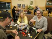 Mike Matthews, from left, Megan Thomas and Tyler Swan, all of Vancouver, enjoy Legos and beers at the Salmon Creek Burgerville. Matthews lamented how adults must &quot;pack up and put away&quot; so much of what&#039;s really fun in life -- but not Legos, he said.