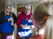 Jeanne Al-Ghamdi, left, and her mother, Diana Webber, greet children as they make the rounds with Sam's Art Cart at Legacy Salmon Creek Medical Center on Dec. 19.