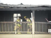 Fire fighters clean up a fire that destroyed an apartment complex at the Bridge Creek apartments Sunday March 16, 2014 in Vancouver, Washington.