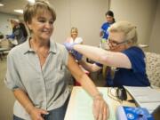 Dena Tornow gives patient Jackie Hadder a flu shot during a flu vaccine clinic Thursday at Kaiser Permanente Salmon Creek Medical Office. Health officials are urging people to get their flu shot soon, before the flu begins circulating.