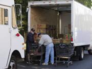 Salvation Army volunteers Greg Puppo, left, and Bill Davis, load up donated bakery items into their truck Tuesday at the Salmon Creek Safeway.