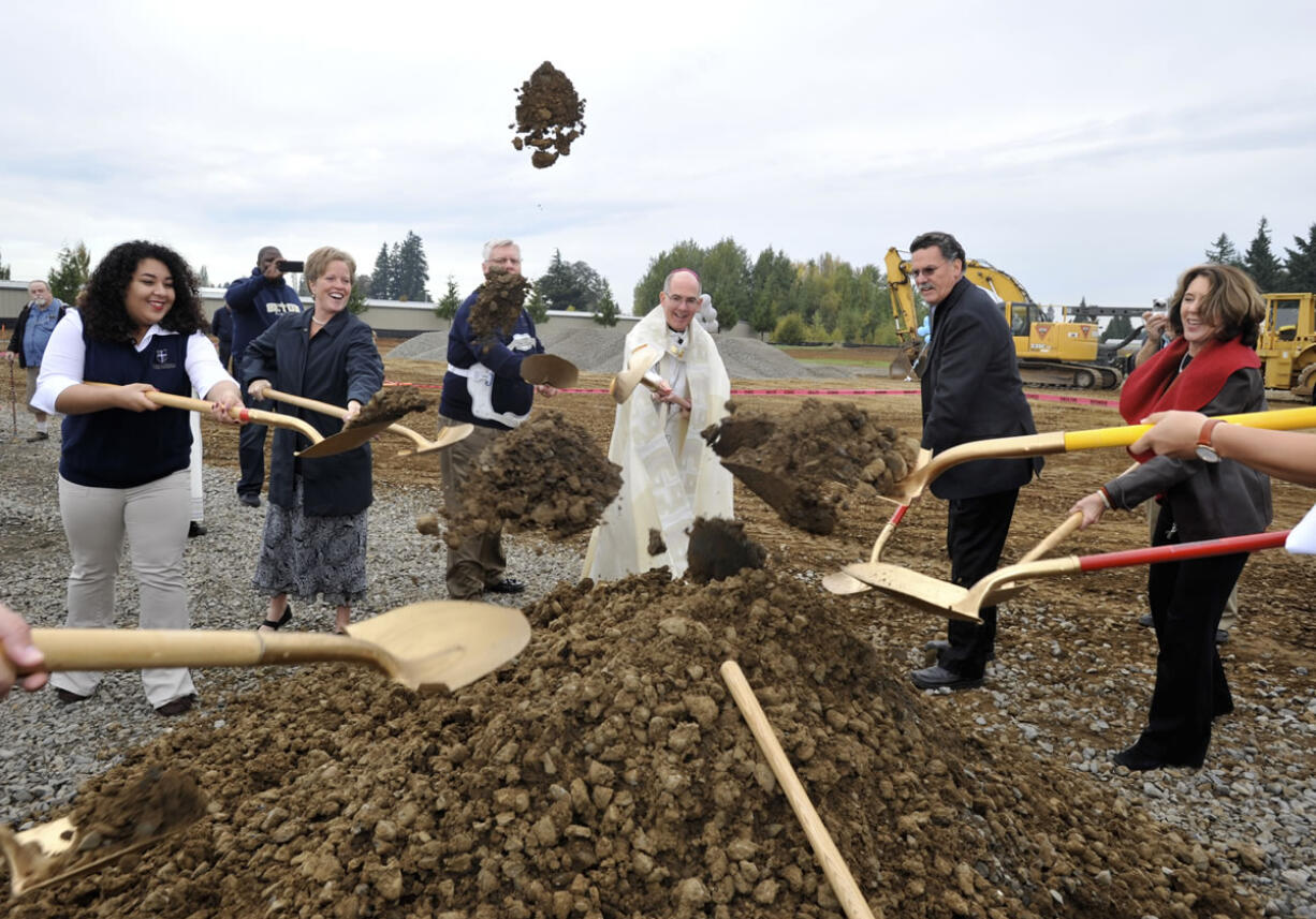 Archbishop of Seattle J. Peter Sartain, center, helps shovel dirt at a blessing and groundbreaking ceremony Saturday on the future site of Seton Catholic College Preparatory High School in Vancouver. The new building is scheduled to open for next school year in September.