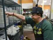 Clinton Cotton puts away dishes during his shift at the Fisher’s Landing New Seasons Market.