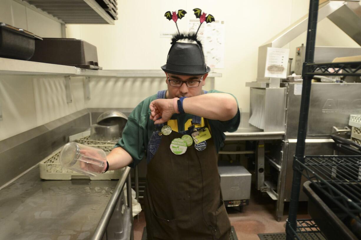 Clinton Cotton jokingly makes a store announcement into his watch, which he pretends is an intercom, at the Fisher’s Landing New Seasons Market, where he works as a dishwasher and performs other duties. Cotton, who has Fragile X Syndrome, was recognized as employee of the year at Wednesday’s Clark County Disability Employment Awareness Month Celebration.