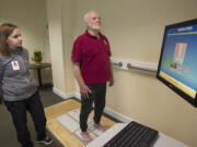 Vancouver resident John Marshall, 77, under the guidance of exercise specialist Tiffany Bunn, tests his balance on new Balance Master technology at Touchmark at Fairway Village in Vancouver.