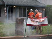 Mike Rice, left, and Mark Hopkins, with pressure washer, work on the front yard of veteran Richard H. Postell&#039;s Hazel Dell home Thursday.