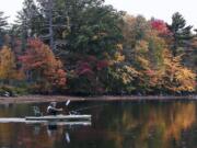 Bruce Hughes, of Hudson, N.H., paddles past trees turning color while heading out to fish for rainbow trout at Canobie Lake in Salem, N.H. New England&#039;s fall foliage is a little less glorious this autumn, as experts say a hotter than usual September and a dearth of rainfall are two reasons for the late and largely muted color display.