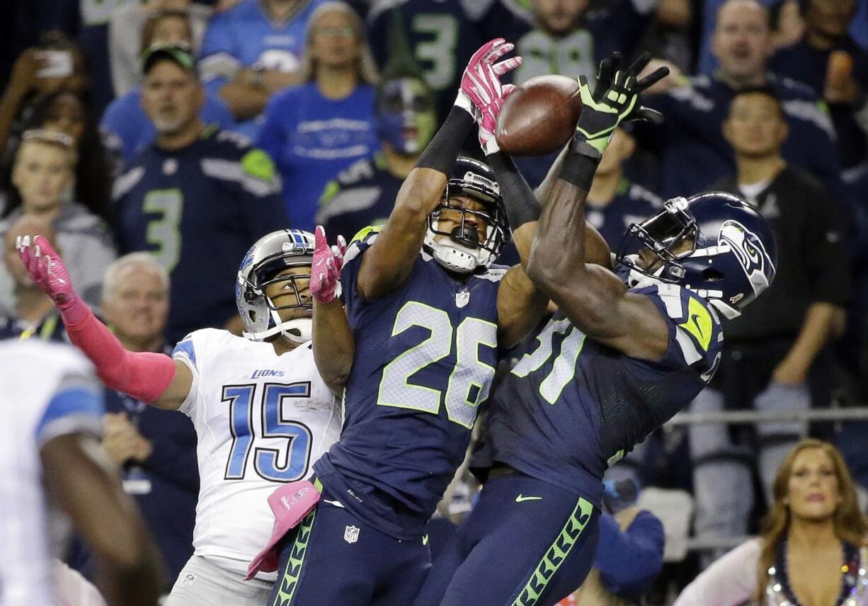 Seattle Seahawks strong safety Kam Chancellor, right, and cornerback Cary Williams (26) break up a pass intended for Detroit Lions wide receiver Golden Tate (15) in the second half Monday.