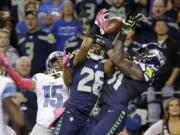 Seattle Seahawks strong safety Kam Chancellor, right, and cornerback Cary Williams (26) break up a pass intended for Detroit Lions wide receiver Golden Tate (15) in the second half Monday.