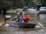 J.B. Neckar, right, and his brother Johnny Neckar, left, paddle their mother Gelene Neckar, center, from her flooded home near Downsville, Texas, Saturday, Oct. 24, 2015. Heavy rains have forced parts of the Brazos River out of its banks and endangering homes located in the small community just outside of Waco, Texas, according to the Waco Tribune Herald.