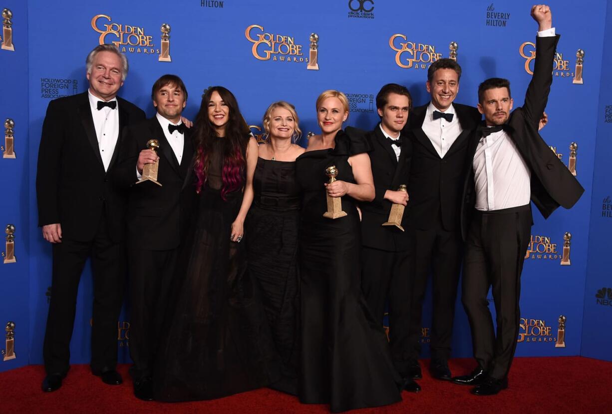 Jonathan Sehring, from left, Richard Linklater, Lorelei Linklater, Cathleen Sutherland, Patricia Arquette, Ellar Coltrane, John Sloss and Ethan Hawke pose in the press room Sunday with the award for best drama for &quot;Boyhood&quot; at the 72nd annual Golden Globe Awards at the Beverly Hilton Hotel in Beverly Hills, Calif.